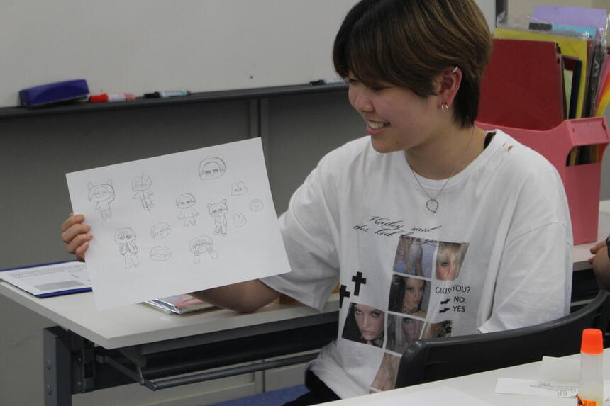 自分で描いたミニキャラを紹介する生徒の様子