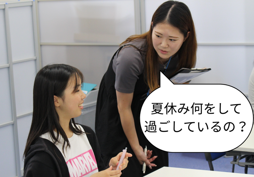 コーチと生徒が夏休みについて楽しく会話をしている様子