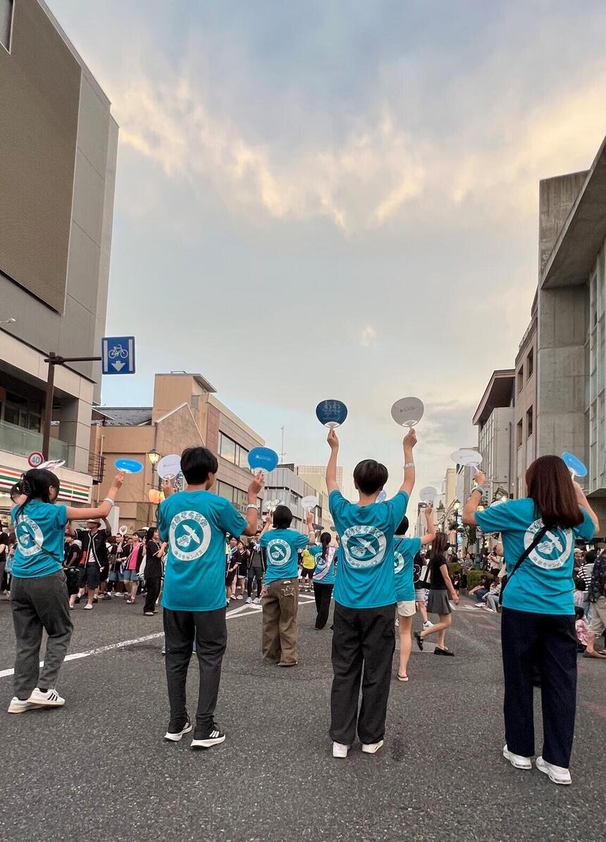 オリジナルのTシャツを着て、楽しそうに踊る生徒とコーチの様子