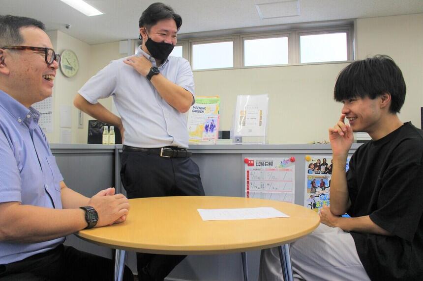 キャンパスでコーチたちと談笑する卒業生