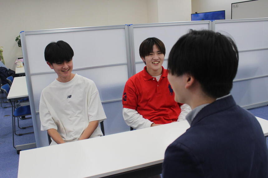 コーチと楽しく話す生徒二人の姿