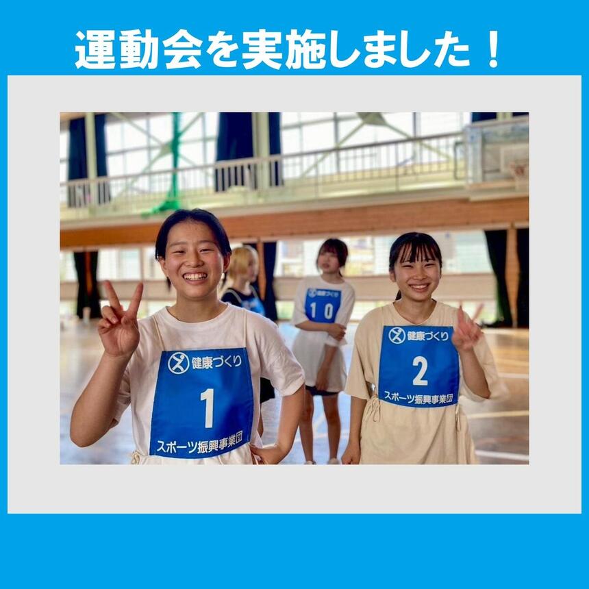 体育館でピースをする青ゼッケンの女子生徒2名　画像作成ツール：PowerPoint 使用フォント：HGP 創英角ゴシックUB