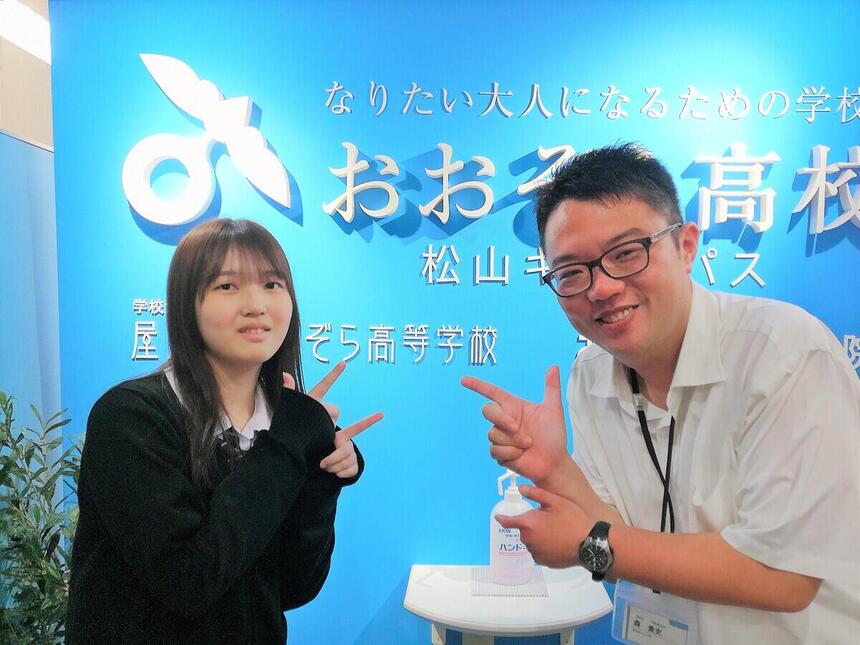 松山キャンパスの1年生の生徒が、マイコーチとキャンパスの入り口で撮影した写真です。