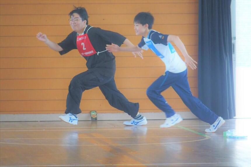 6月10日の運動会にて2人の男子生徒がチーム対抗リレーに出場して走っている写真
