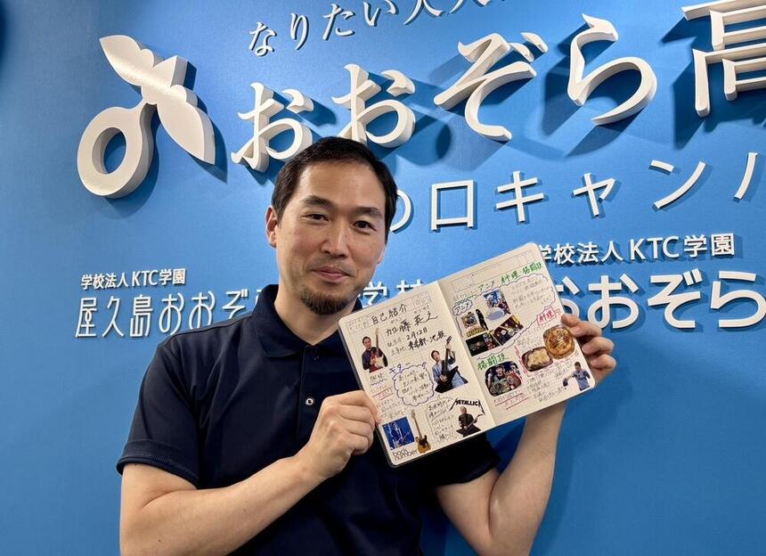 溝の口キャンパスで自己紹介ページを開いて紹介している加藤コーチ