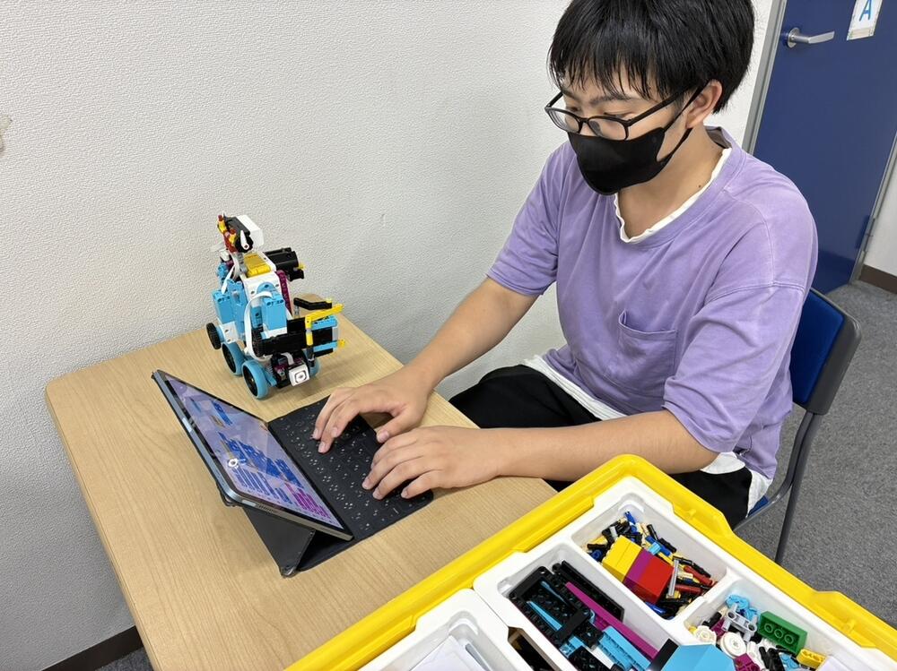 ブブロックを持ち上げて運ぶことができるロボットと生徒