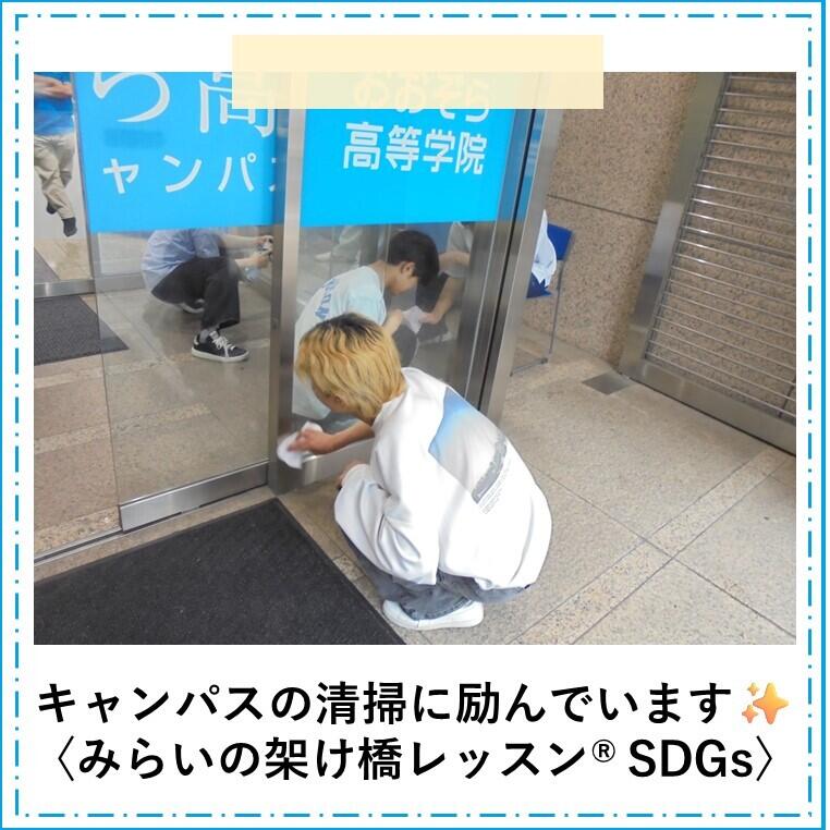 みらいの架け橋レッスン®「SDGs」の時間に男子生徒2名がキャンパスのドアを清掃している様子
