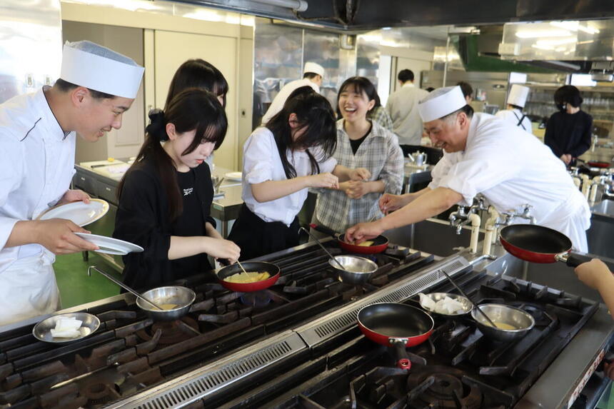 専門学校でみらいの架け橋レッスン中に調理のプロから料理を教えてもらう生徒たちの様子