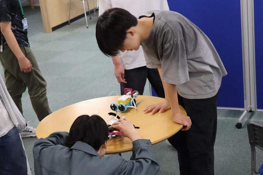 生徒がプログラミングコース体験でロボット相撲をする写真