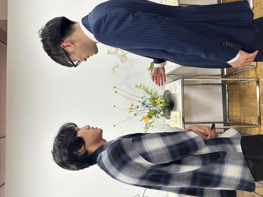 東京華展に参加した生徒が、華展を主催している方と話をしている様子。