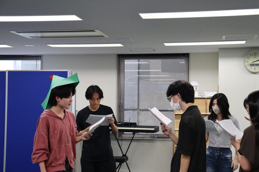キャンパスで中間発表会のため生徒が演劇している様子