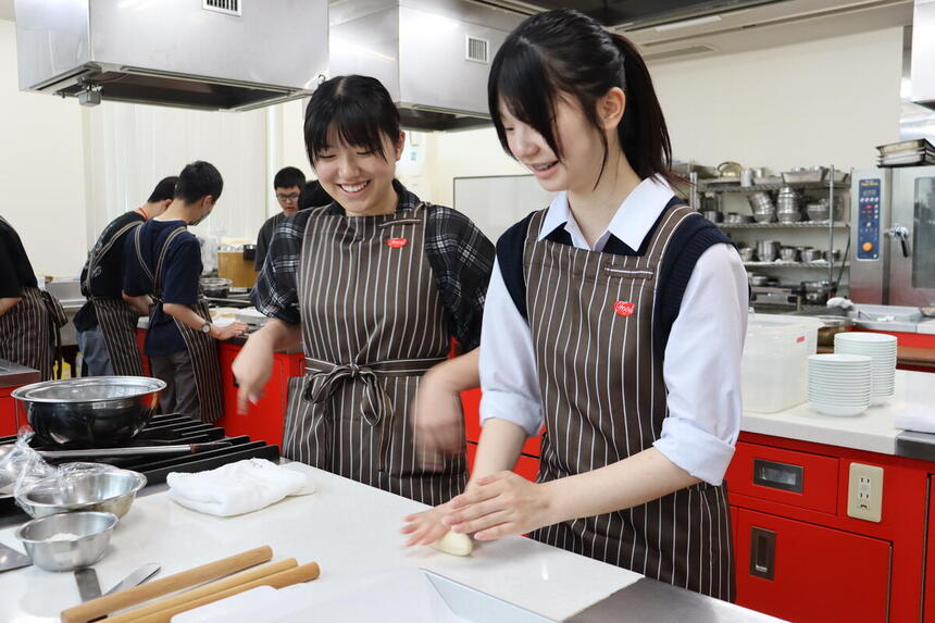 専門学校で餃子の皮を楽しそうに作る生徒の様子