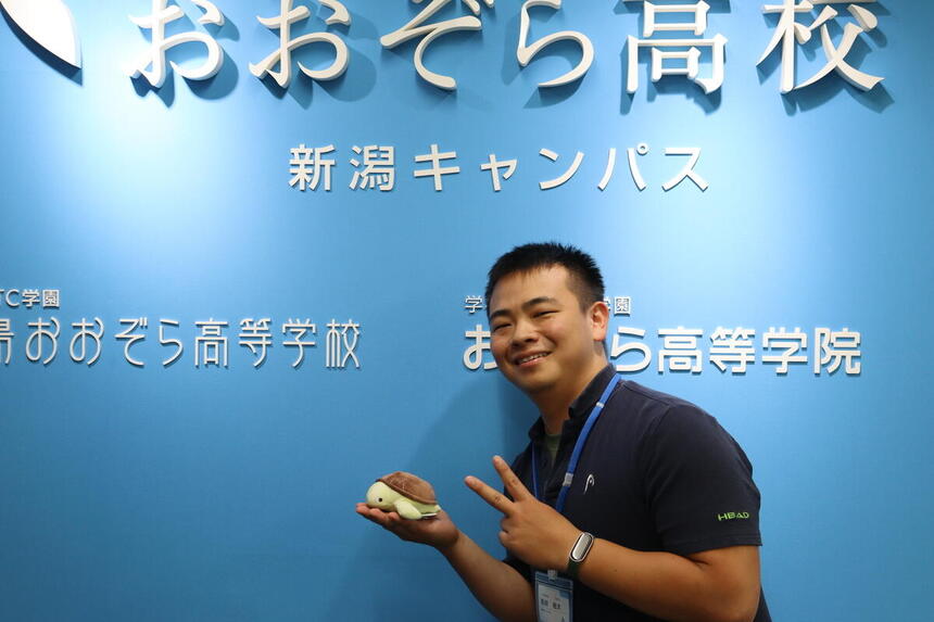 西田コーチが新潟キャンパスの入り口でコーチ紹介の写真を撮りました。