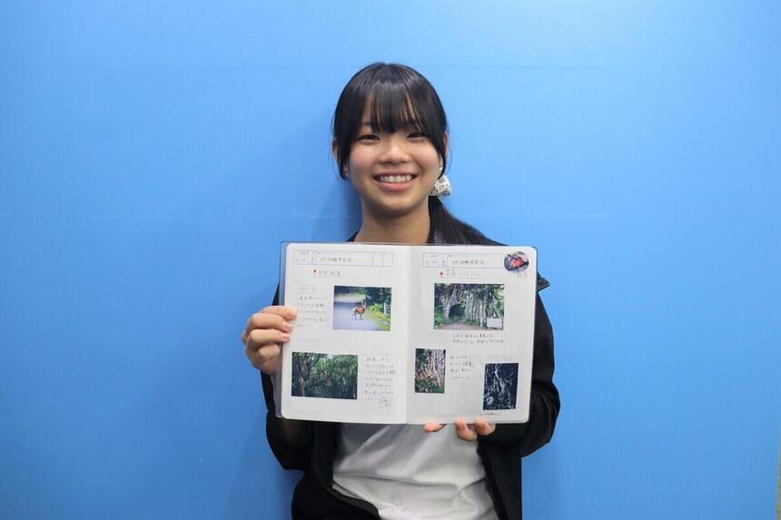 インタビュー対象生徒がみらいノートのページを見せながら笑っている写真