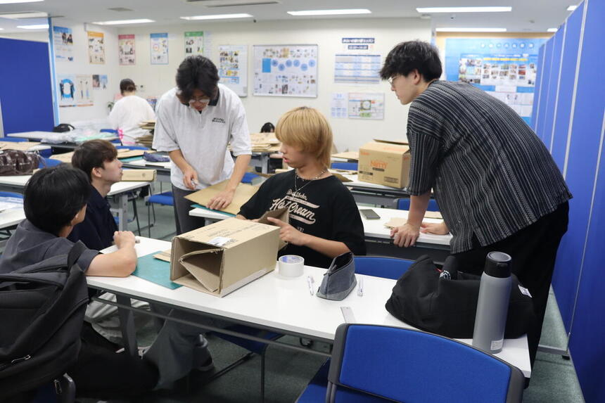 生徒たちがキャンパスで演劇の小道具を作っている様子
