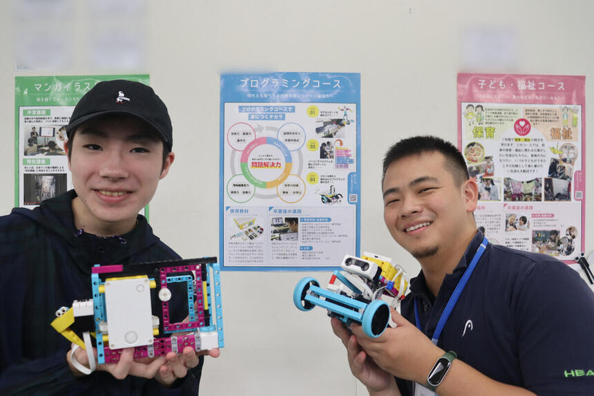 Tくんが自作しているロボットとプログラミングコースのコーチと一緒に記念撮影