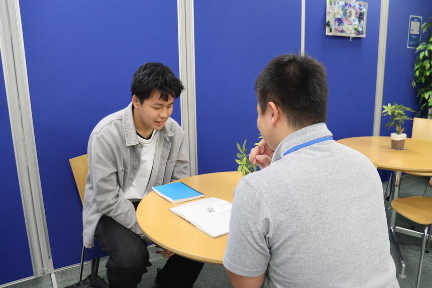 休み時間にコーチと転入学した生徒が話をしている様子