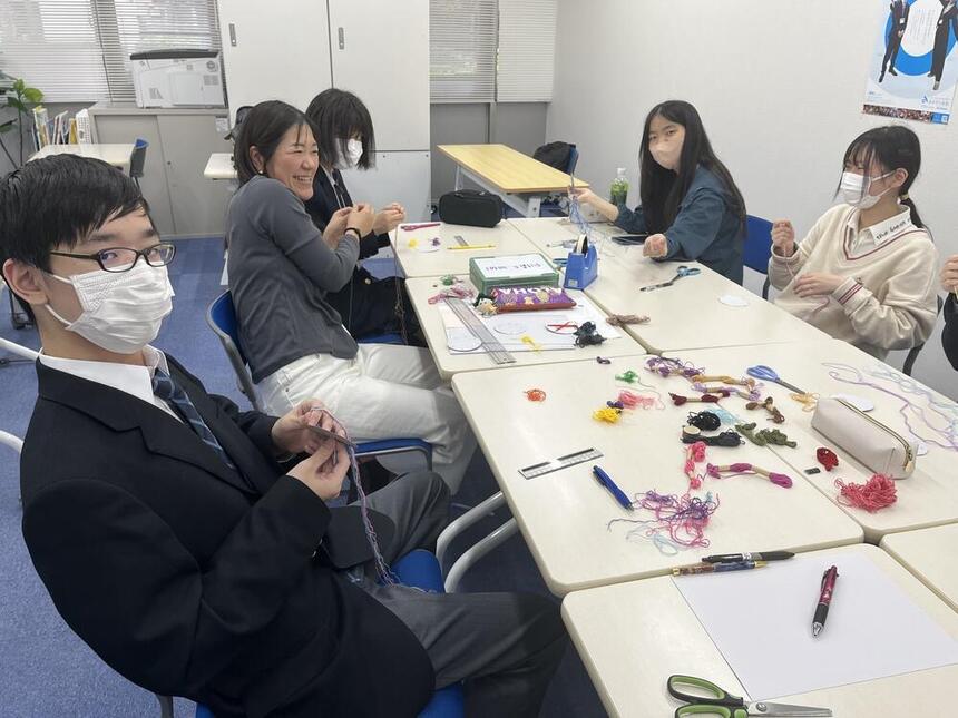 みらいの架け橋レッスン「ものづくり」で、生徒たちがカラフルな紐から 組み紐を作成している写真