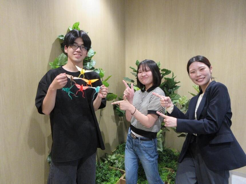 放課後、キャンパスで、ポーズを決めるコーチと在校生２名