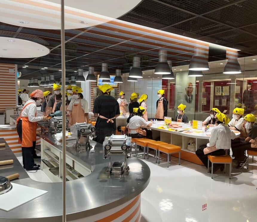 カップヌードルミュージアムで食品作り体験をしながら3学年が交流している様子