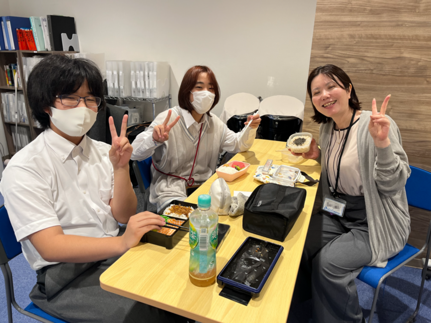 お昼休みにコーチと生徒が一緒に昼食を食べる様子