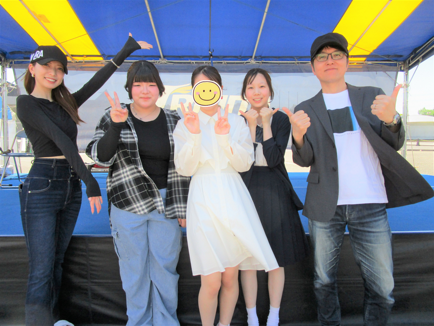 ニータンパークでステージ演奏した生徒とコーチが演奏終了後に笑顔でピースしている様子