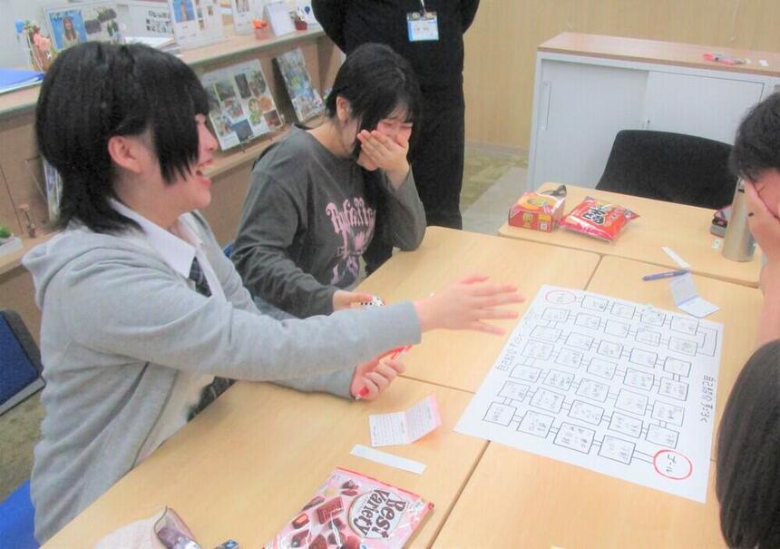 新入生歓迎会で生徒たちが自己紹介すごろくをして笑っている様子