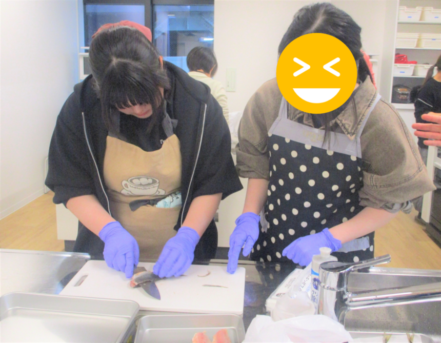 調理室で魚をさばいている2名の生徒