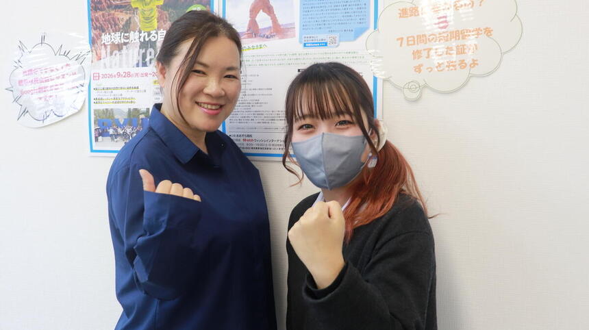 教室内で、在校生とコーチが一緒にガッツポーズをしている様子の写真
