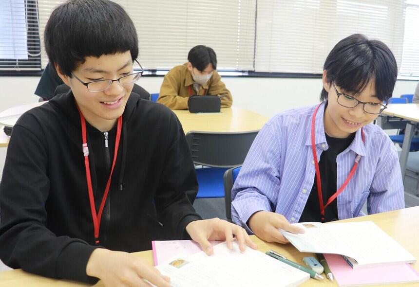 教室で二人の男子学生が授業を受けている様子