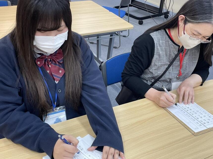 みらかけの時間に教室で書道をしている生徒とコーチの様子