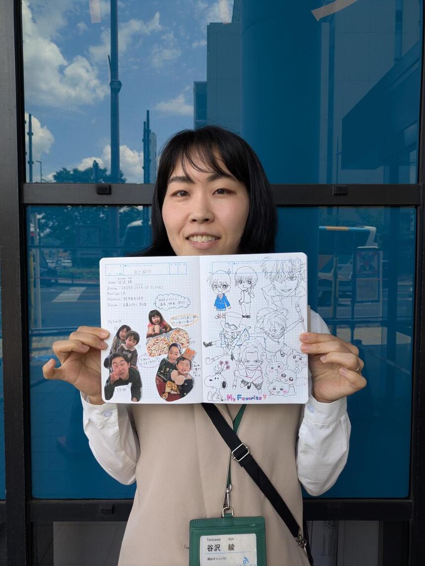 谷沢コーチが教室前でみらいノートを開いて見せている写真