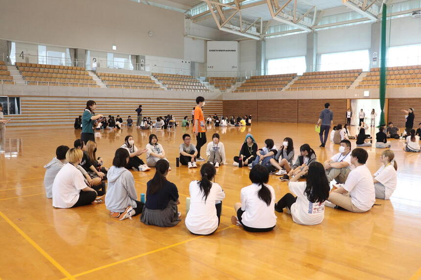 6月の交流会で行われたイベントの様子。チームごとに輪になり自己紹介をしています。