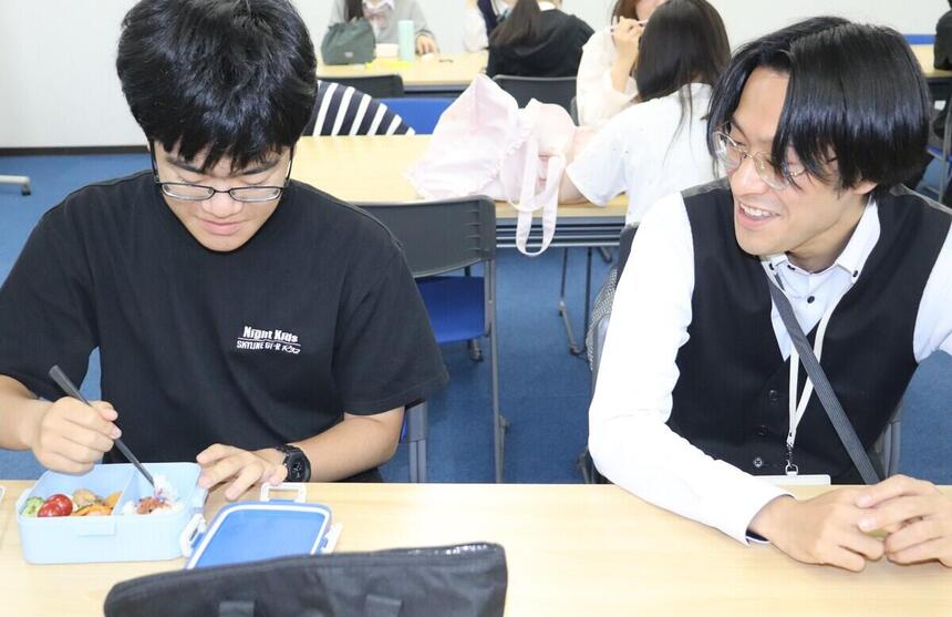 休憩時間に教室で生徒とコーチが談笑している様子