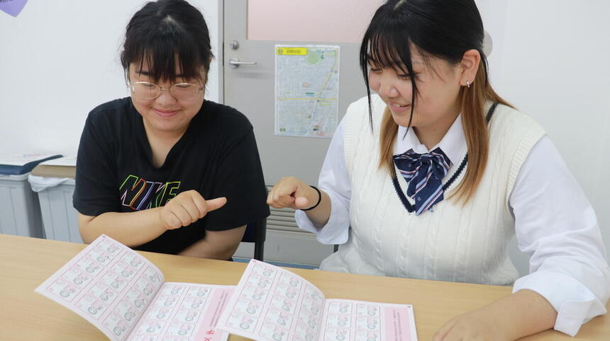 オープンキャンパスの際、おおぞら高校の在校生が参加された中学生の方にネイルチップの作り方をレクチャーしている様子。