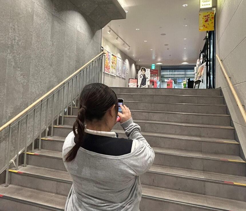 引いたくじの色を探して撮影しようとする生徒