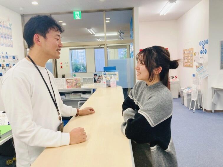 カウンター越しに話す生徒とコーチ