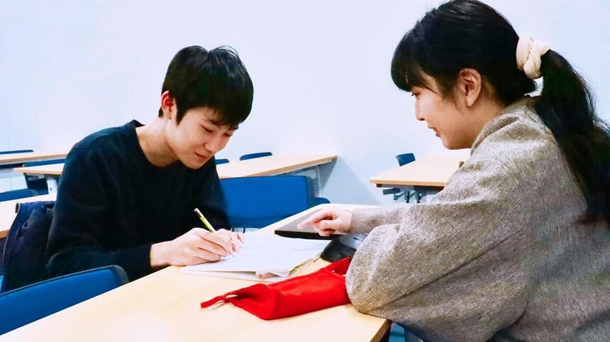 勉強をする生徒と教えるコーチ