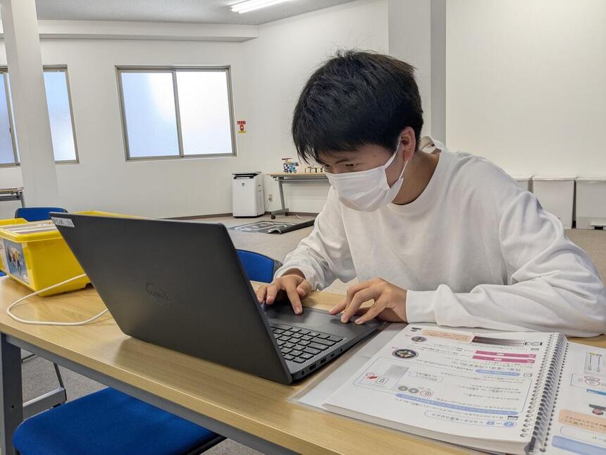 プログラミングコース在籍生が教室でプログラムを組んでいる男子生徒