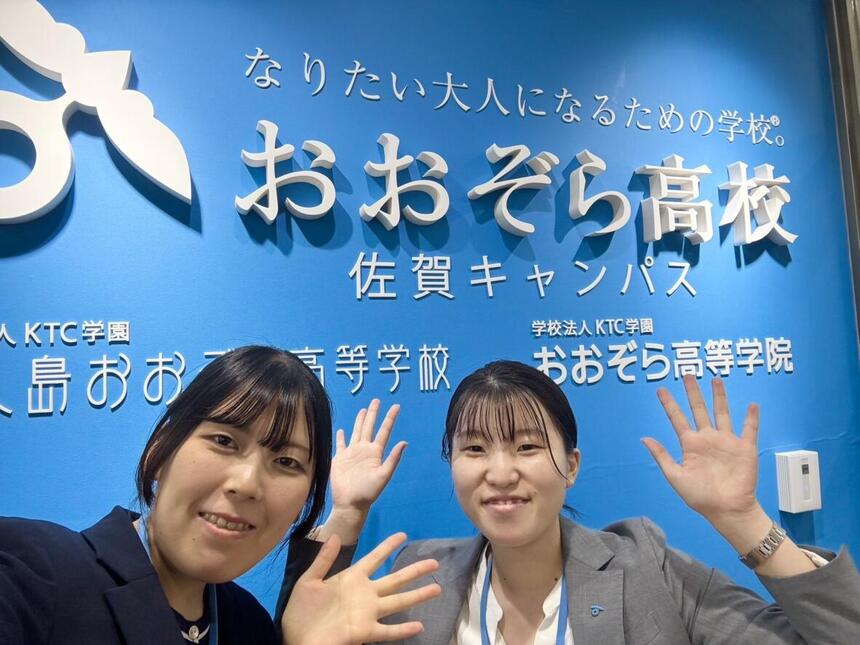 フロントサインの前で写真を撮った入学相談室の2人