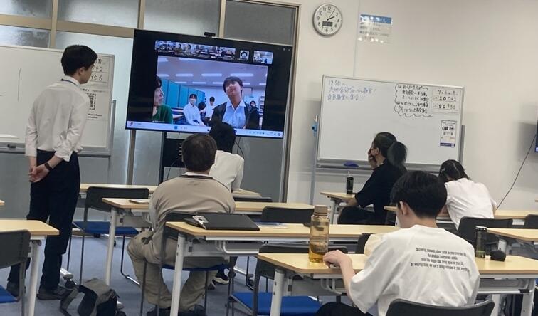 キャンパスの教室で留学についての話を熱心に聞く複数の生徒