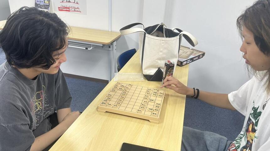 教室内で将棋（ボードゲーム）を楽しむ男子生徒２名