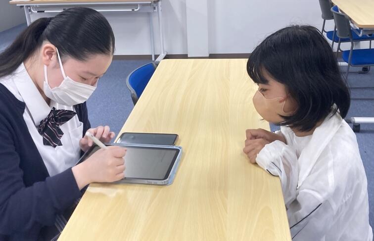 タブレットで一生懸命ハングル文字を書いている生徒