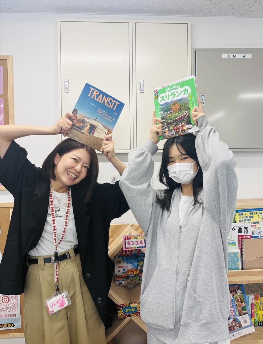 キャンパス長と留学先の雑誌をもって写真を撮るYさん