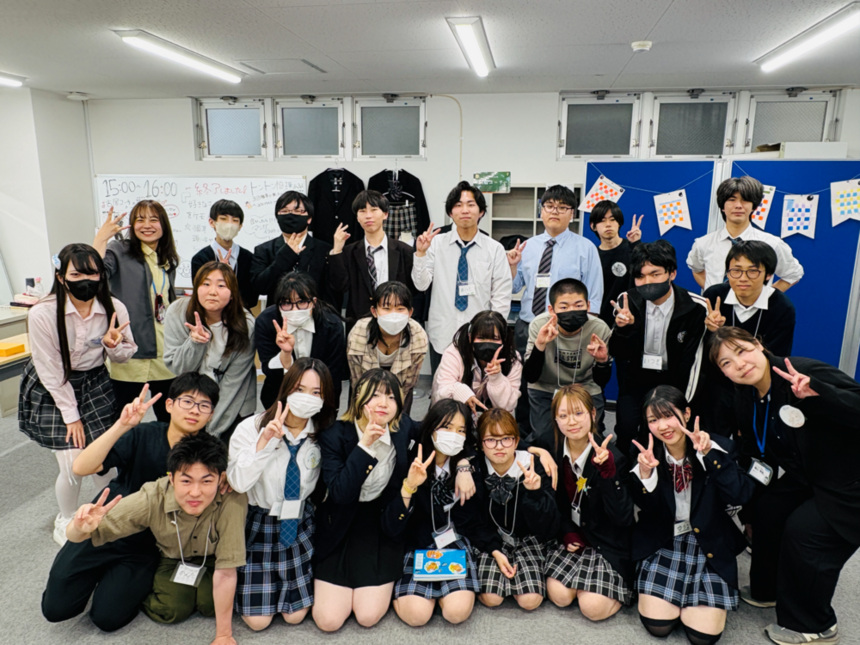 オープンキャンパス後に達成感に満ちた大勢の生徒が笑顔でピースをしている写真
