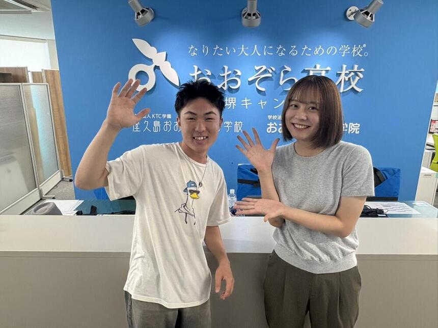 Kさんとマイコーチがキャンパスで笑顔で写真に写っている様子