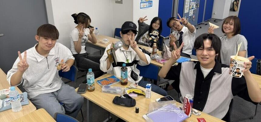 堺キャンパスにて、昼休み中に生徒とコーチが一緒に昼食を取っている光景。カメラに向かってみんなでポーズ。