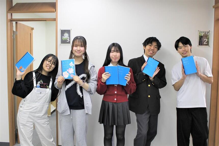 オープンキャンパス準備中の在校生がKTCみらいノート®とともに笑顔の写真