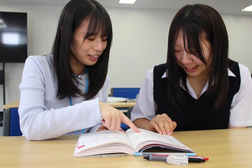 コーチが進学コースの生徒の隣に座って学習のサポートをしている様子