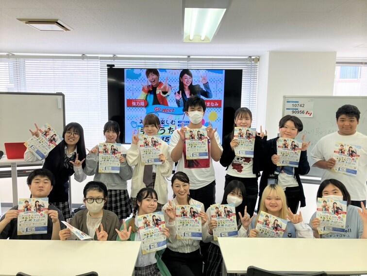 サインヴォーカリストの水戸まなみさんを中心に、参加した生徒らが手話のポーズで映っている様子